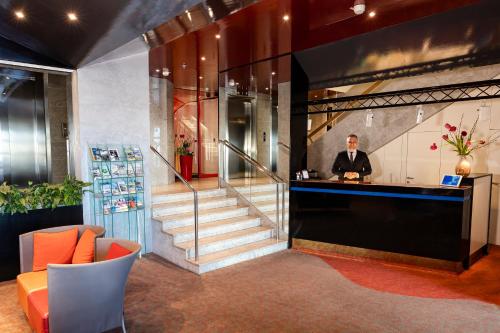 a man standing at a bar in a lobby at Hotel Roth am Strande in Westerland