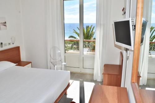 a bedroom with a bed and a window with the ocean at Hotel Boncardo in Finale Ligure