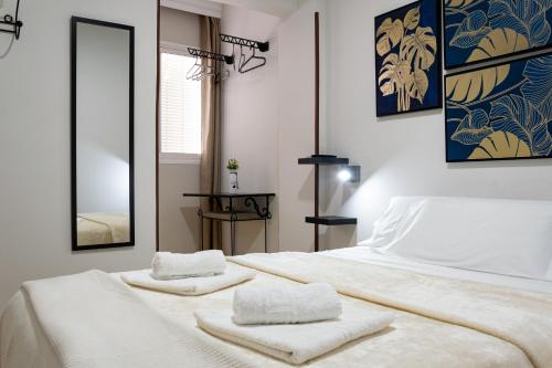 a bedroom with a white bed with towels on it at Hostal Cuevas in Fuengirola