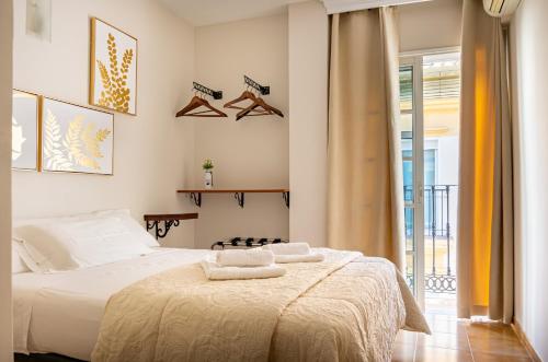 a bedroom with a large white bed with towels on it at Hostal Cuevas in Fuengirola