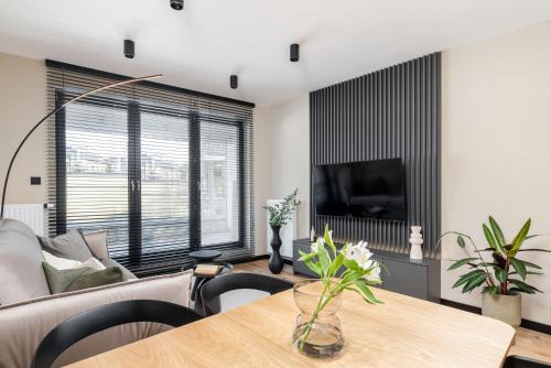 a living room with a table and a couch at Malila Premium Apartments Cracow Centre Wiślane Tarasy 2 0 in Krakow