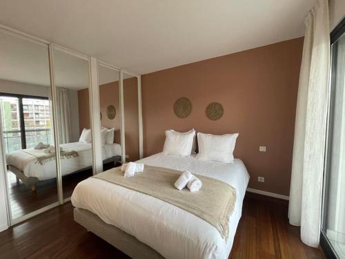 a bedroom with a large bed with towels on it at Le Mont-Veyrier, parking et vue in Annecy