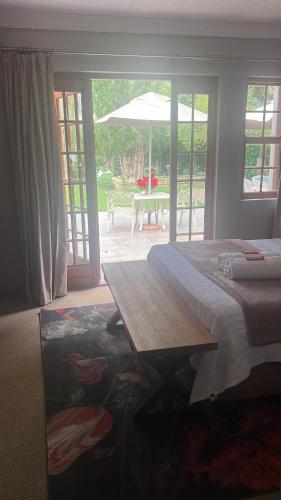 a bedroom with a bed and a table with an umbrella at Zwartmodder Clarens in Clarens