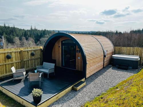 - un kiosque en bois avec une baignoire sur la terrasse dans l'établissement Highland Premier Glamping Pods, à Beauly