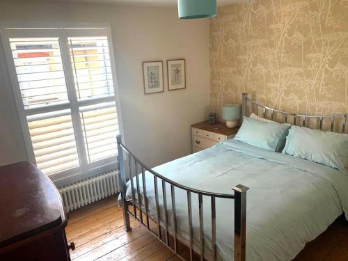 um quarto com uma cama e uma janela em Heart house fisherman’s cottage em Kent