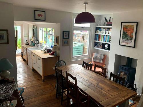 a kitchen and dining room with a wooden table and chairs at Heart house fisherman’s cottage in Kent