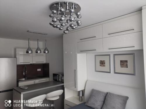 a living room with a couch and a chandelier at Sunset Home Apartman in Siófok