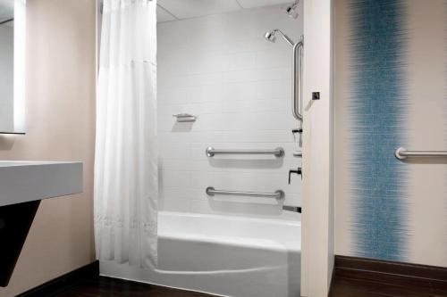 a bathroom with a shower curtain and a bath tub at Des Moines Marriott Downtown in Des Moines