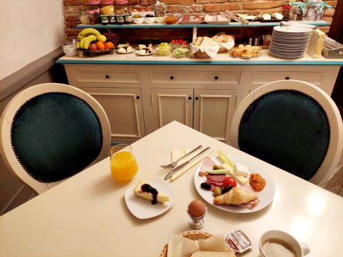 una mesa con dos platos de comida y un vaso de zumo de naranja en Casa Timpuri Vechi, en Sibiu