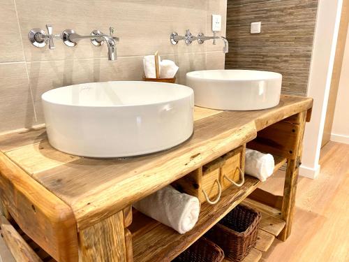 a bathroom with two sinks on a wooden counter with towels at Domaine Baruteau in Soustons