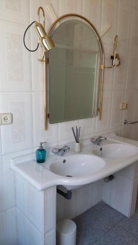y baño con lavabo blanco y espejo. en Chalet Cantalejo, en Cantalejo