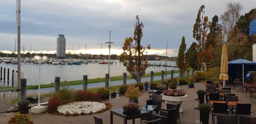 a view of a marina with tables and chairs at Akzent Hotel Strandhalle in Schleswig