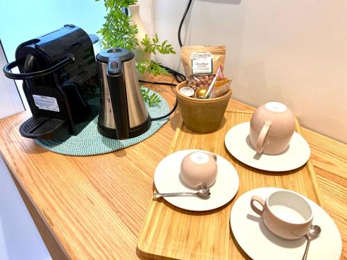 a wooden table with two cups and a coffee maker at Domaine Baruteau in Soustons