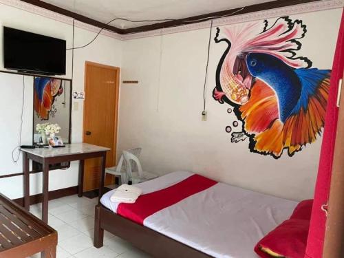 ein Schlafzimmer mit einem Pfauenmal an der Wand in der Unterkunft RedDoorz at Kaffe De Oro Hotel Socorro Oriental Mindoro in Socorro