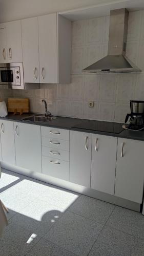 a kitchen with white cabinets and a sink at Chalet Cantalejo in Cantalejo