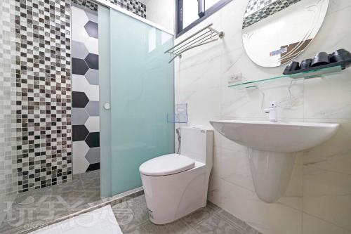 uma casa de banho com um lavatório, um WC e um espelho. em 忘憂海HappinesSea em Xiyu
