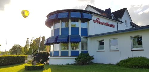 a kite is flying above a building with at Akzent Hotel Strandhalle in Schleswig