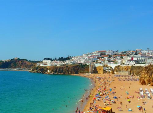 a group of people on a beach near the water at Residence Pé na Areia in Albufeira