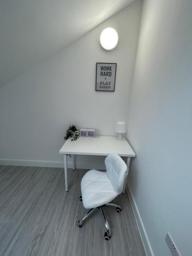 a white desk with a white chair in a room at Modern London Apartment in London