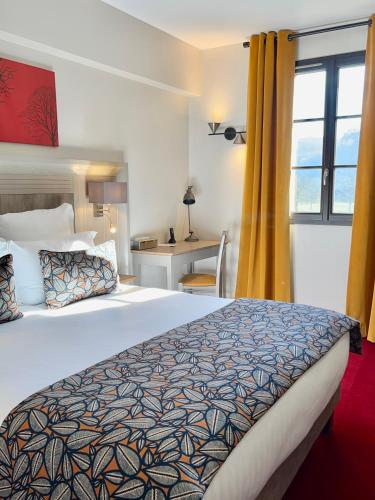 a hotel room with a large bed and a window at Hotel Le Perigord in La Roque-Gageac