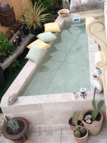 une piscine dans un jardin avec des plantes en pot dans l'établissement le clos girona, à Civrac-en-Médoc