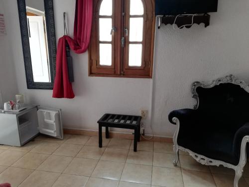 a living room with a black chair and a table at Riad côté jardin in Saly Portudal