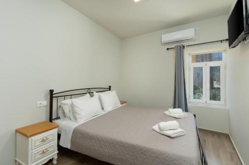 a bedroom with a bed with two towels on it at Avli Village Home with Outdoor Jacuzzi in Vafés