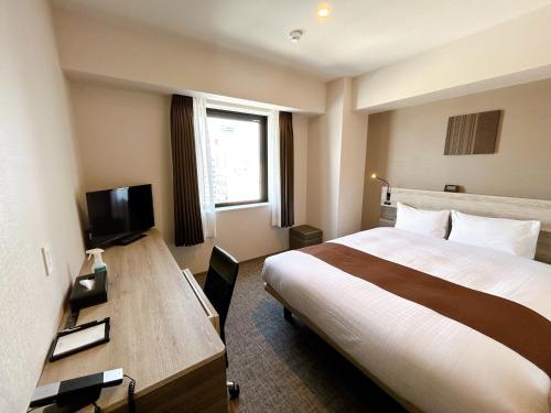 a hotel room with a bed and a television at Smile Hotel Premium Hakodate Goryokaku in Hakodate