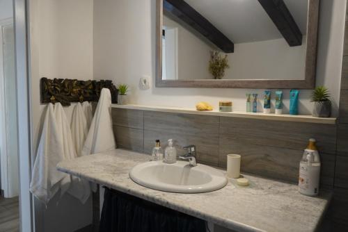 ein Badezimmer mit Waschbecken und Spiegel in der Unterkunft Apartment Barone Šibenik - city view & free parking in Šibenik