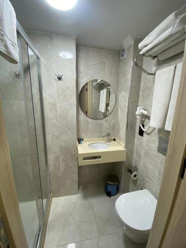ein Badezimmer mit einem WC, einem Waschbecken und einem Spiegel in der Unterkunft Otel Yenikapı in Istanbul