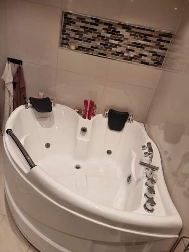 una vasca da bagno bianca seduta in bagno di Cosy room with luxurious bathroom a Flateby
