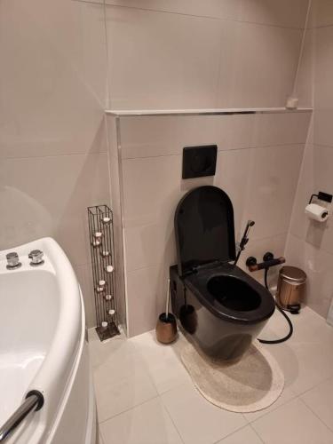 a bathroom with a black toilet and a sink at Cosy room with luxurious bathroom in Flateby