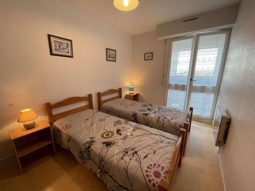 une chambre avec deux lits et une fenêtre dans l'établissement Appartement cosy proche plage avec balcon et vue mer - FR-1-224C-48, à Saint-Hilaire-de-Riez