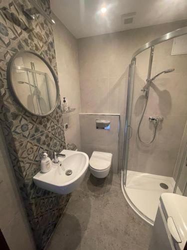 uma casa de banho com um lavatório, WC e um espelho. em Friendly Apartment em Cracóvia
