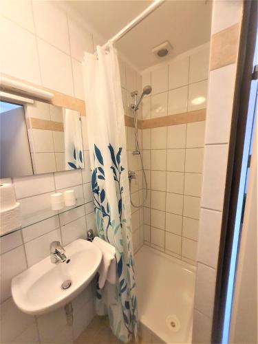a bathroom with a sink and a shower and a toilet at Pension Schwartzwirt in Neusiedl am Steinfelde