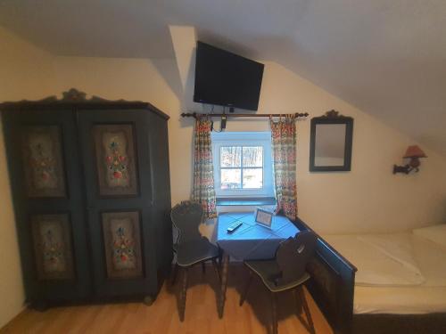 a room with a table and a bed and a window at Pension Schwartzwirt in Neusiedl am Steinfelde