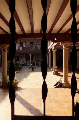 a view through a fence of a courtyard at Hotel Rural Posada Los Caballeros in Almagro