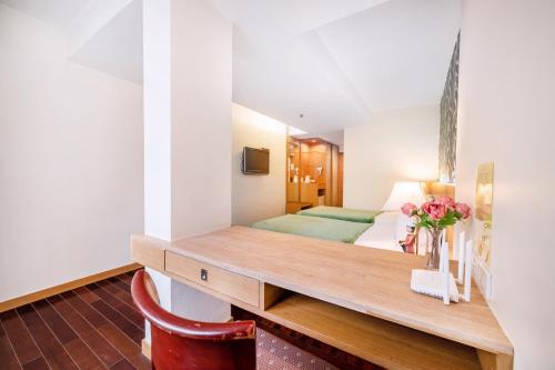 a bedroom with a bed and a desk with flowers on it at P2 Boutique in Bangkok