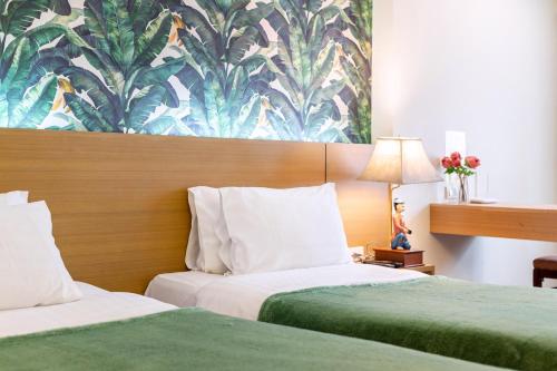 a hotel room with two beds and a floral wallpaper at P2 Boutique in Bangkok
