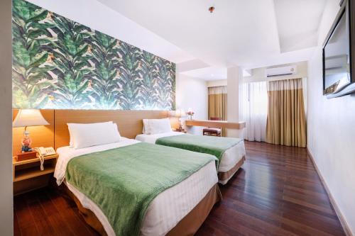 a hotel room with two beds and a painting on the wall at P2 Boutique in Bangkok