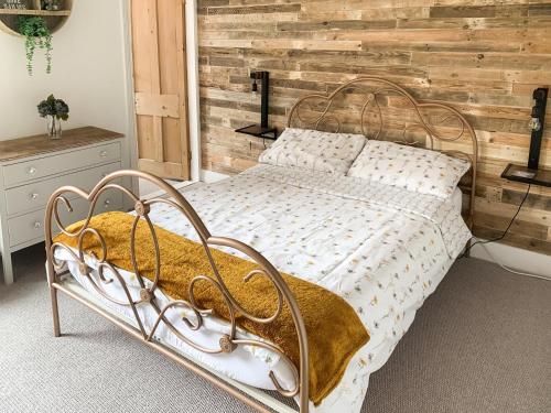 a bedroom with a metal bed with a wooden wall at Whitstable'S Pearl in Whitstable