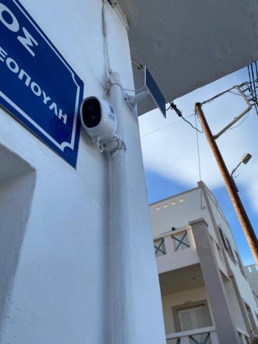 a street sign on a building with a security camera at Olympios Apartment at Myrtos 1 minute from the beach in Myrtos
