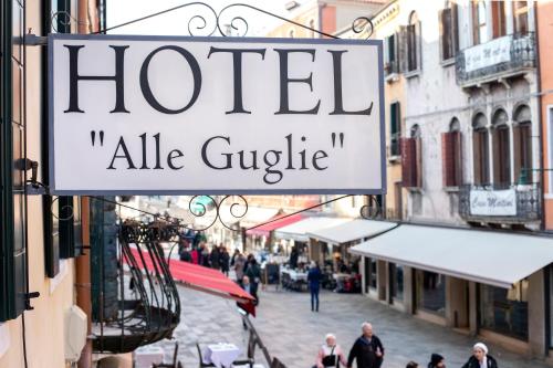 um sinal para um guiggle hotelale pendurado numa rua em Alle Guglie Boutique Hotel em Veneza