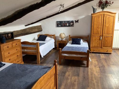 a bedroom with two beds and wooden furniture at Ombre Bleue Du Figuier, Ailhon in Ailhon