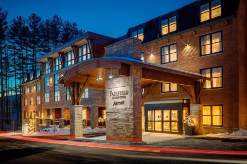 a large brick building with a sign in front of it at Fairfield by Marriott Waterbury Stowe in Waterbury