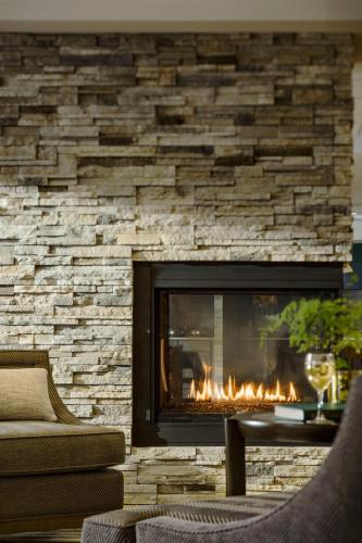 a fireplace in a living room with a stone wall at Fairfield by Marriott Waterbury Stowe in Waterbury