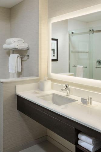 a bathroom with a sink and a large mirror at Fairfield by Marriott Waterbury Stowe in Waterbury