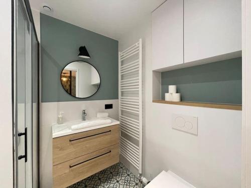 une salle de bain avec un lavabo et un miroir dans l'établissement Quai des Cordeliers, balcon et vieille ville, à Annecy