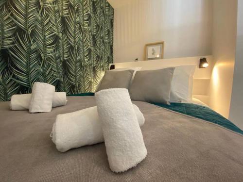 une chambre avec un grand lit avec des oreillers blancs dans l'établissement Quai des Cordeliers, balcon et vieille ville, à Annecy