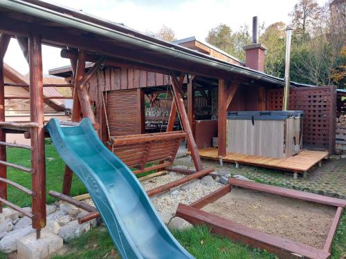 a playground with a slide in front of a house at Chalupa na Hrbku in Belá